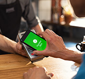 Person using their mobile wallet to pay at coffee shop 